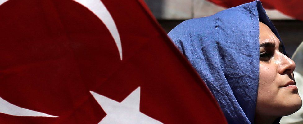 A woman holds a Turkish flag at a pro-government protest