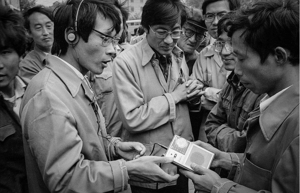 A man shows off a personal cassette player in the street