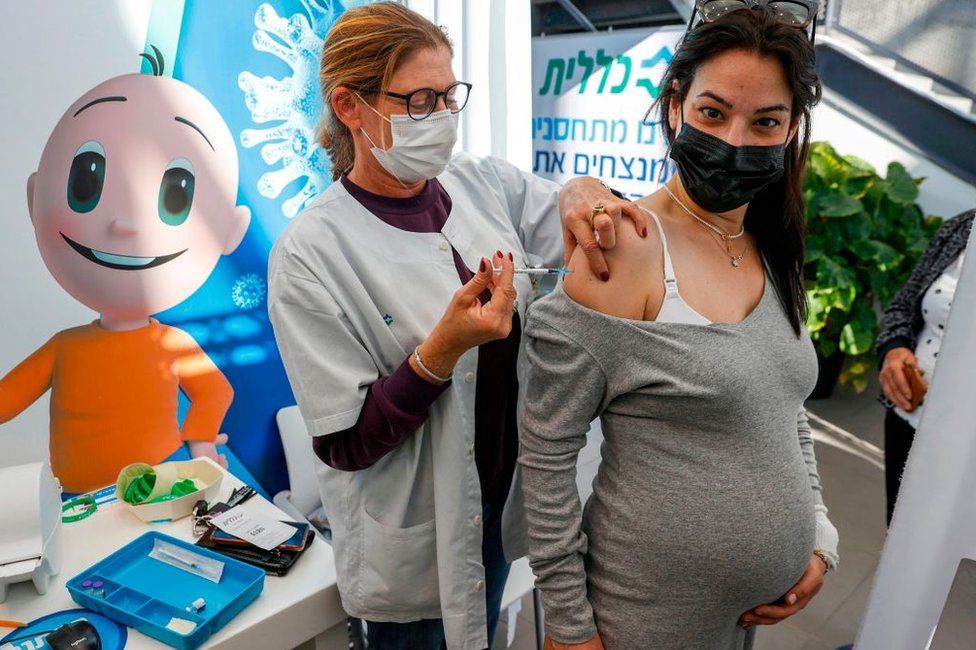 Медицинский работник вводит дозу вакцины от коронавируса Pfizer-BioNtech COVID-19 беременной женщине в клинике Clalit Health Services в израильском прибрежном городе Тель-Авив на средиземноморском побережье 23 января 2021 года.