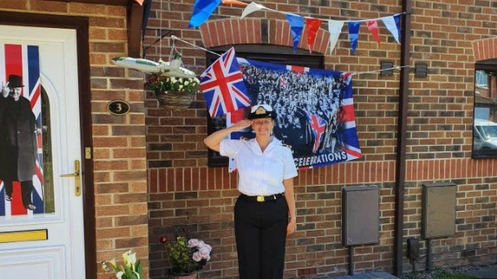 Michelle Welsh, Lt Cdr in the Sea Cadets, standing in front of her house decorated with bunting and flags in Colwick, Nottingham