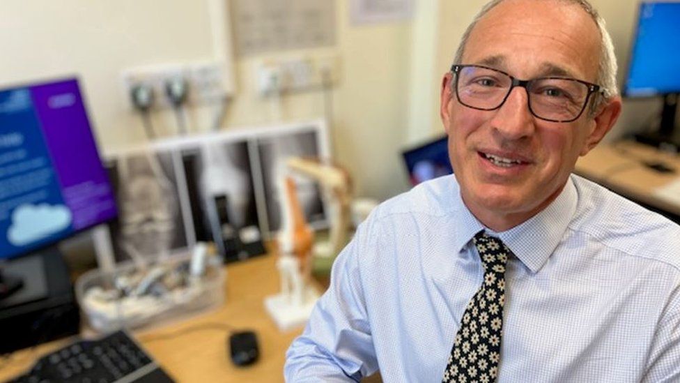 Il Prof. Andrew Toms, direttore di ortopedia al Royal Devon and Exeter Hospital, sorride alla telecamera