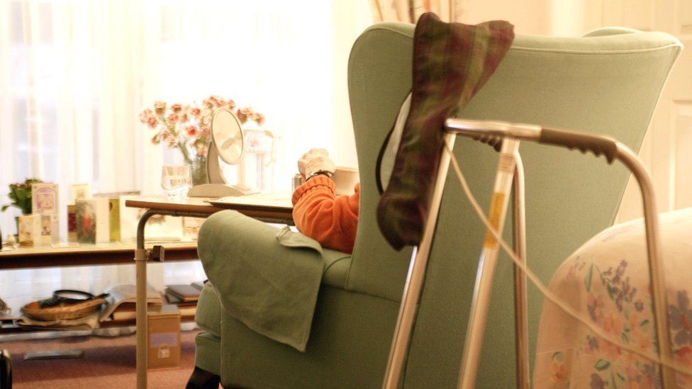Person sitting in chair in care home