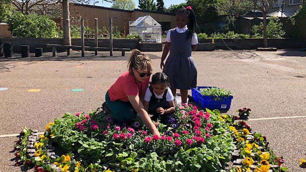Key worker pupils and staff make a rainbow of flowers