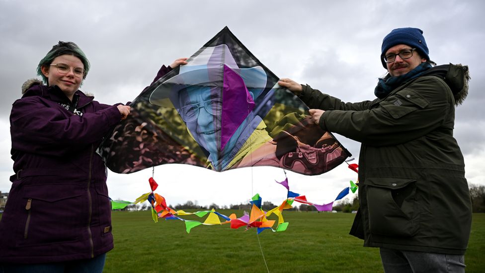 Two people holding a kite