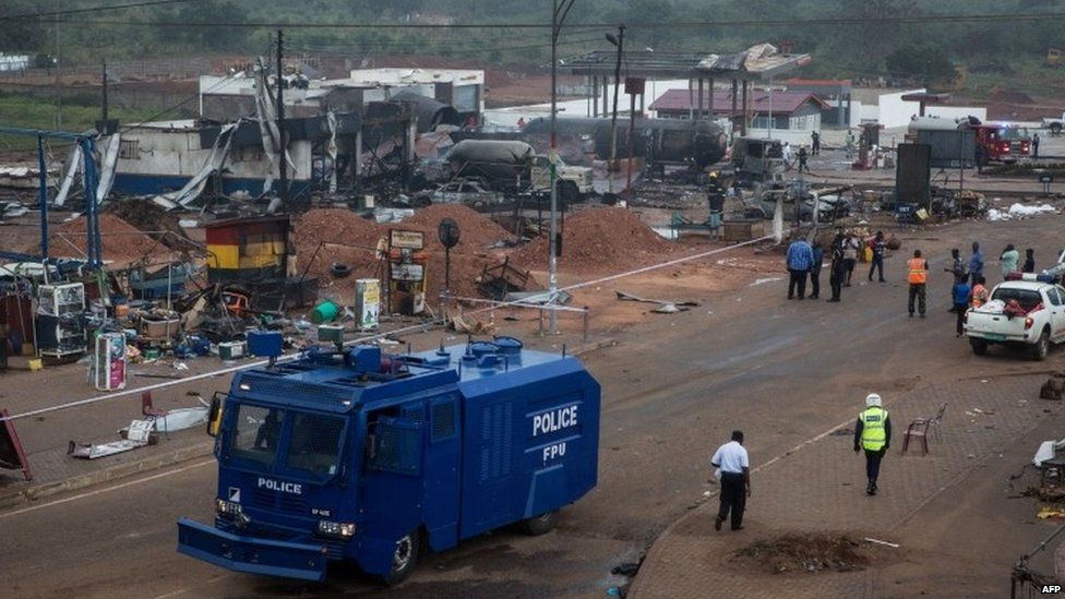 A police vehicle drives on the site of an explosion in Accra on October 8, 2017 a day after a gas tanker caught fire, triggering explosions at two fuel stations