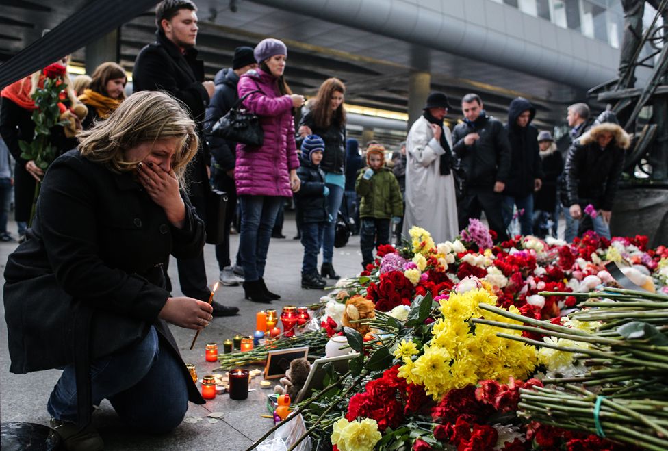 A woman holds a candle at a memorial for the victims of downed Airbus A321, at the Pulkovo Airport on November 1, 2015 in St. Petersburg, Russia.