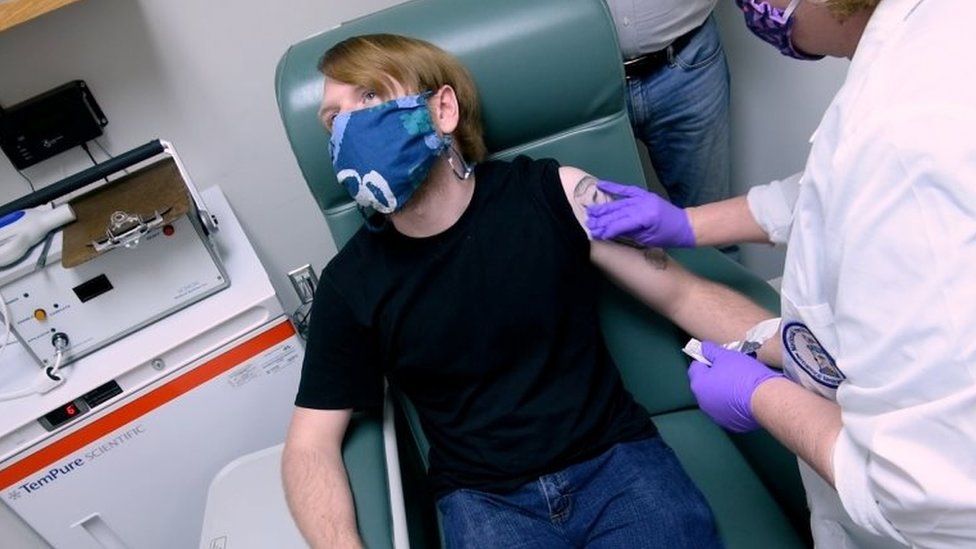 A vaccine trial participant is prepared for injection in Baltimore in May