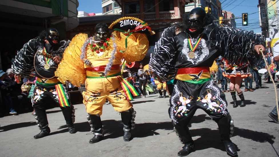 Participants wearing masks parade down the streets of La Paz