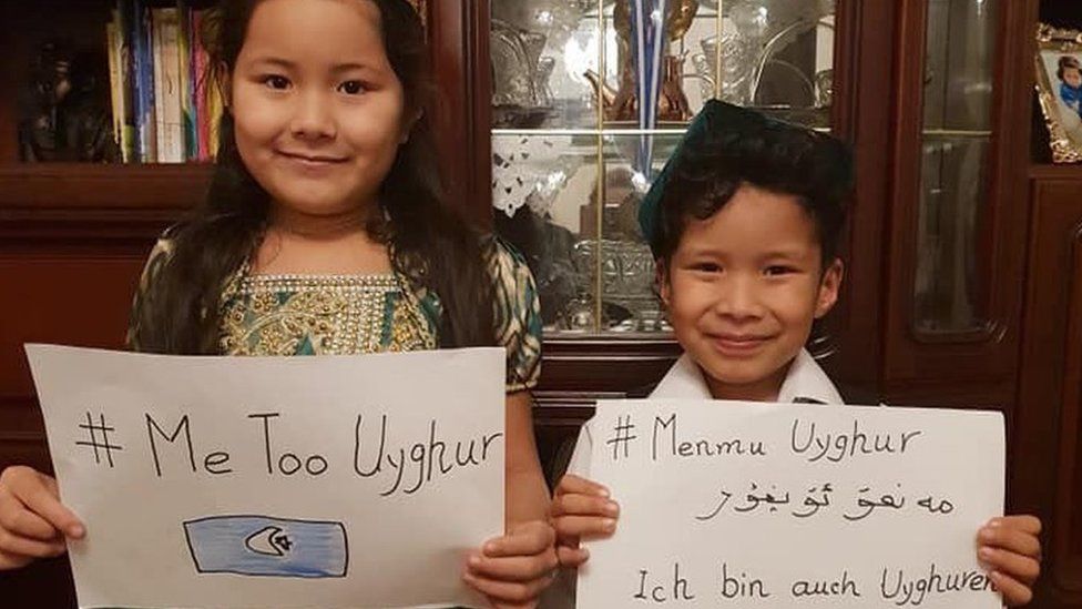 Two children holding up #MeTooUyghur posters