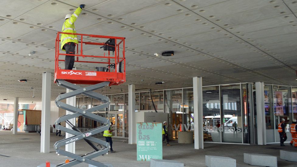 Trabajador en el exterior de los estudios Aviva, Manchester