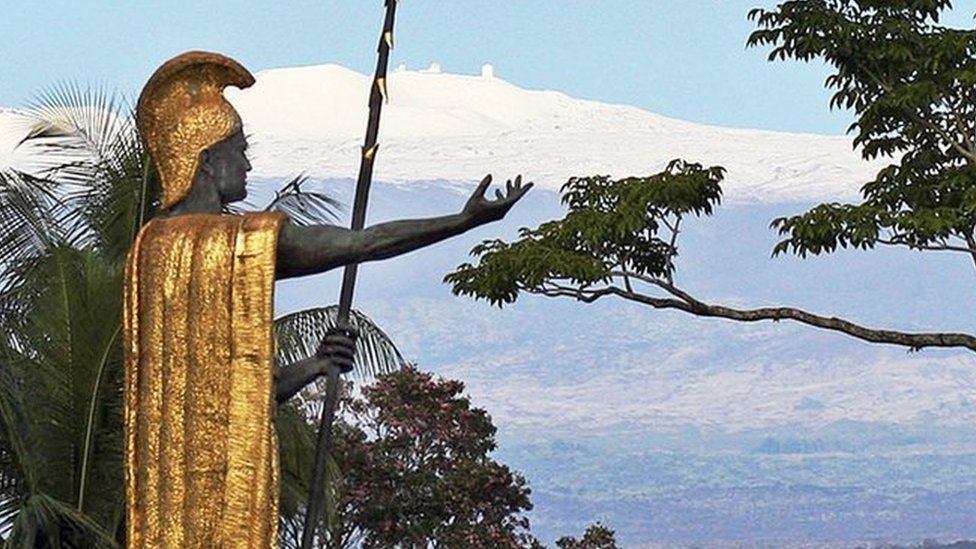This Jan. 31, 2014, file photo, shows a statue of Hawaiian King Kamehameha I with snow-capped Mauna Kea in the distance, in Hilo, Hawaii.