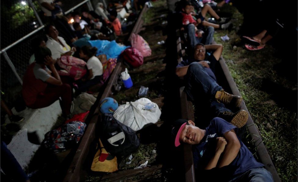 Honduran migrants rest on the bridge that links Mexico and Guatemala, in Ciudad Hidalgo, Mexico