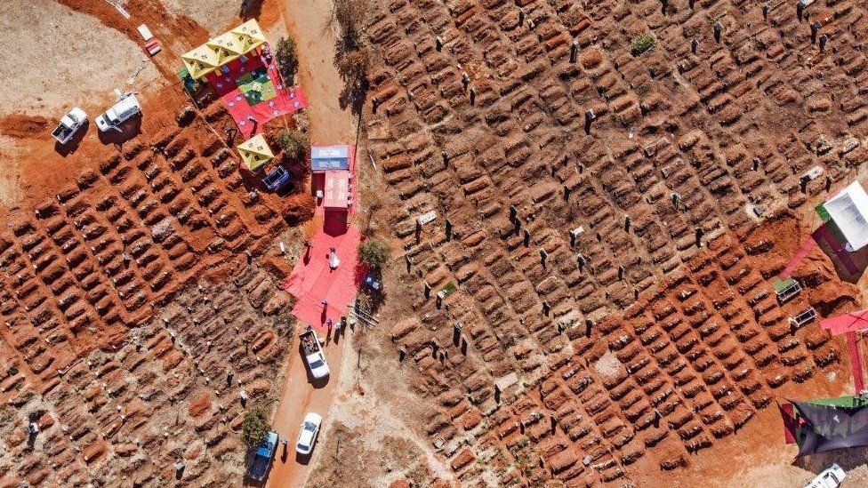 This aerial picture shows several funerals being celebrated at the Olifantsvlei Cemetery in Soweto, on July 25, 2020.