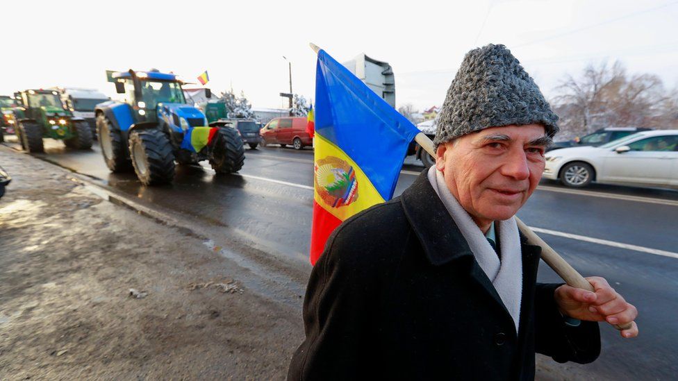 A supporter holds a Romanian flag during a tractor protest near Bucharest
