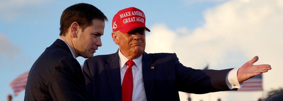 Donald Trump invites Sen. Marco Rubio to speak at the microphone during a rally at the Miami-Dade County Fair and Exposition
