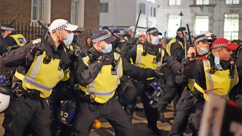 Police officers clash with protesters in central London