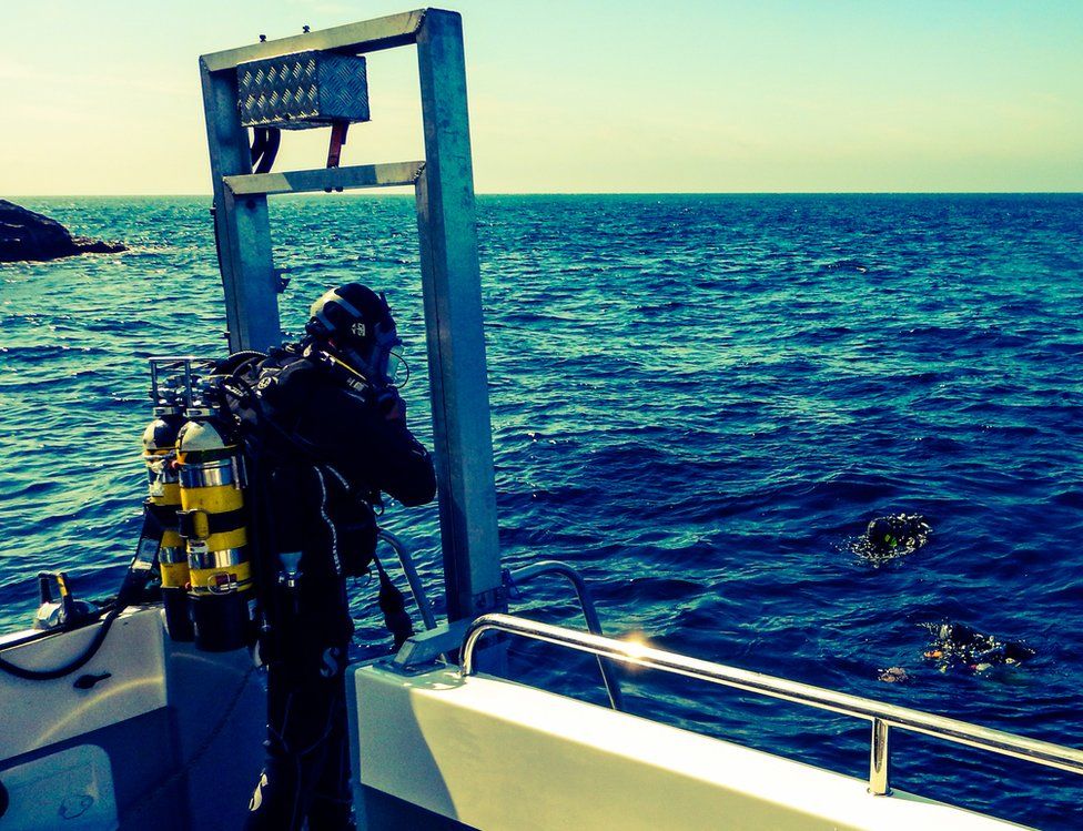 A diver prepares to enter the water to investigate the site of La Girona wreck