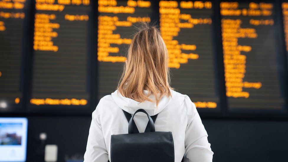 Woman looking a train departure board