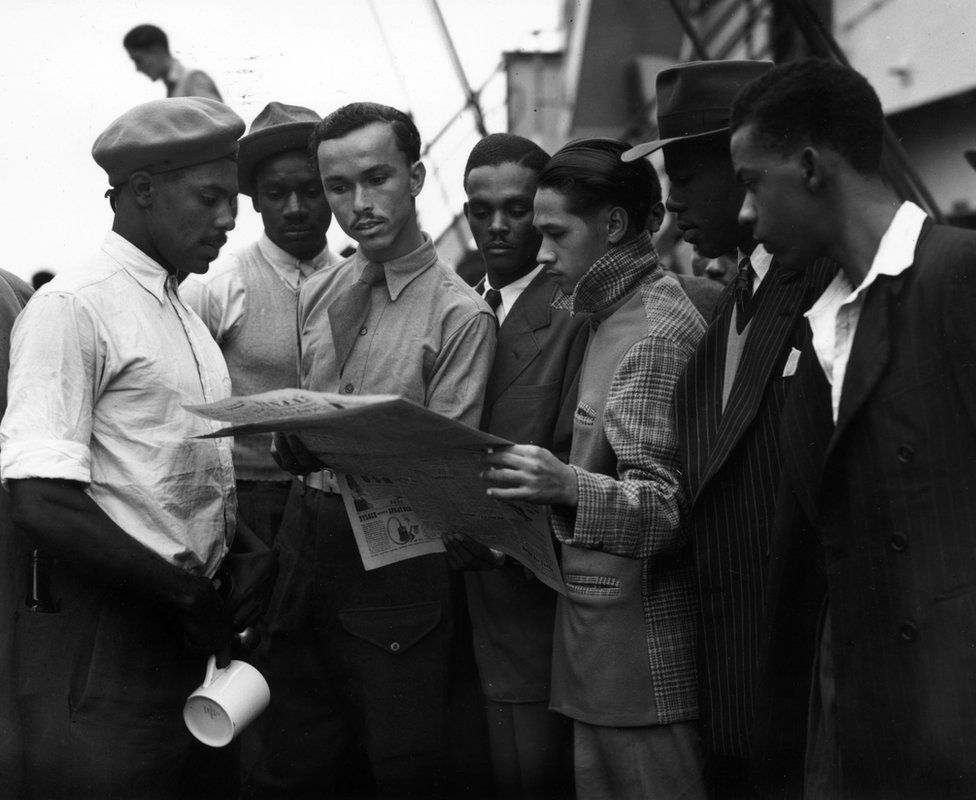 Immigrants on board the 'Empire Windrush' reading a newspaper