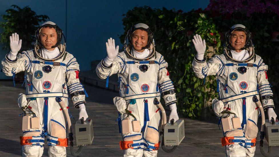 Chinese astronauts from China's Manned Space Agency, left to right, Tang Hongbo, Nie Haisheng, and Liu Boming wave at a departure ceremony