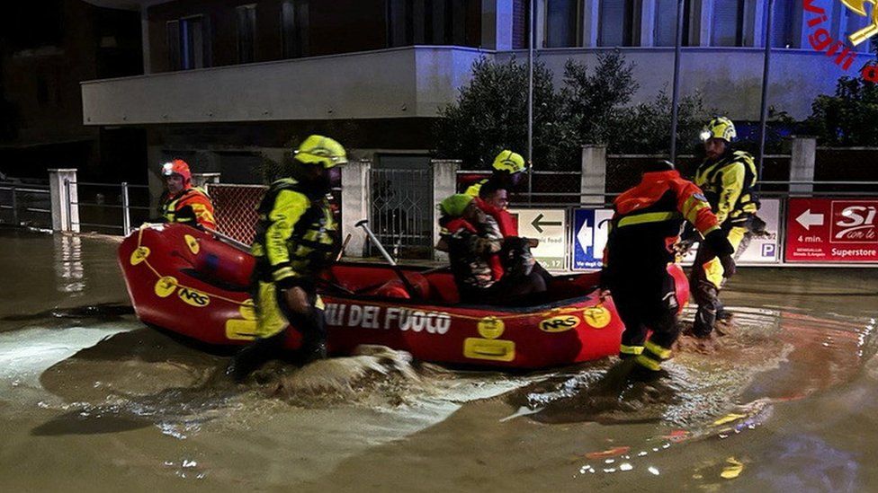 Image shows dinghy in flooded street