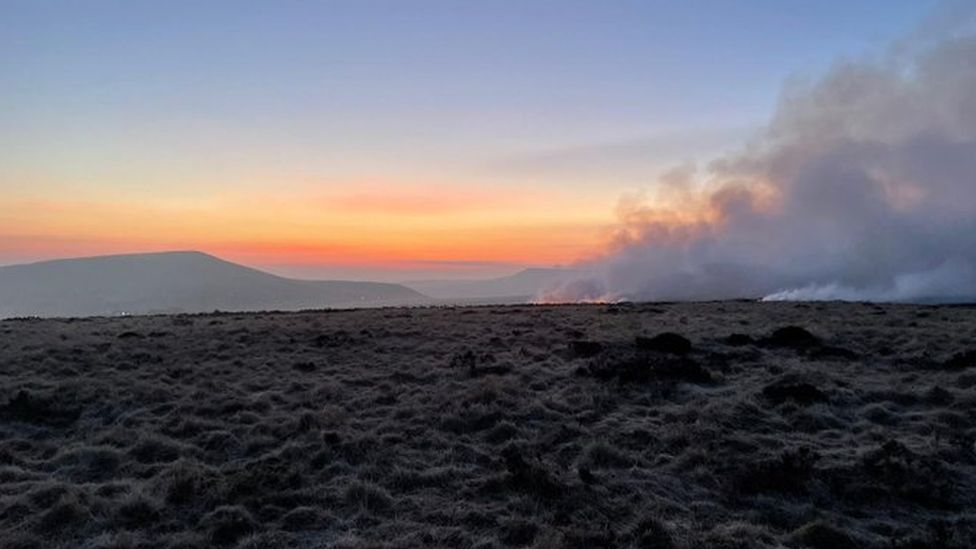 Smoke rising from Marsden Moor fire as sun rises