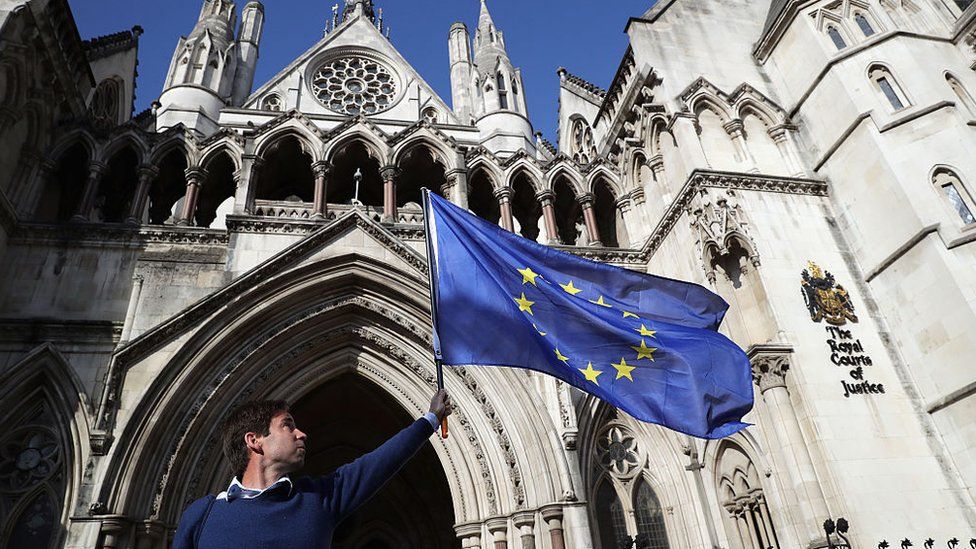 'People's Challenge' member waves an EU flag outside the Royal Courts of Justice on October 13, 2016 in London, England