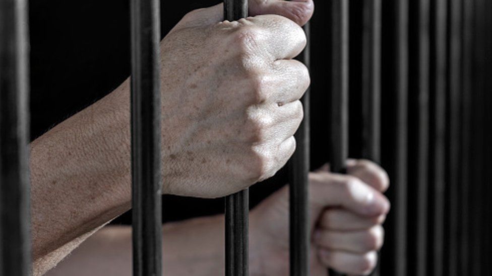 A man holding prison bars