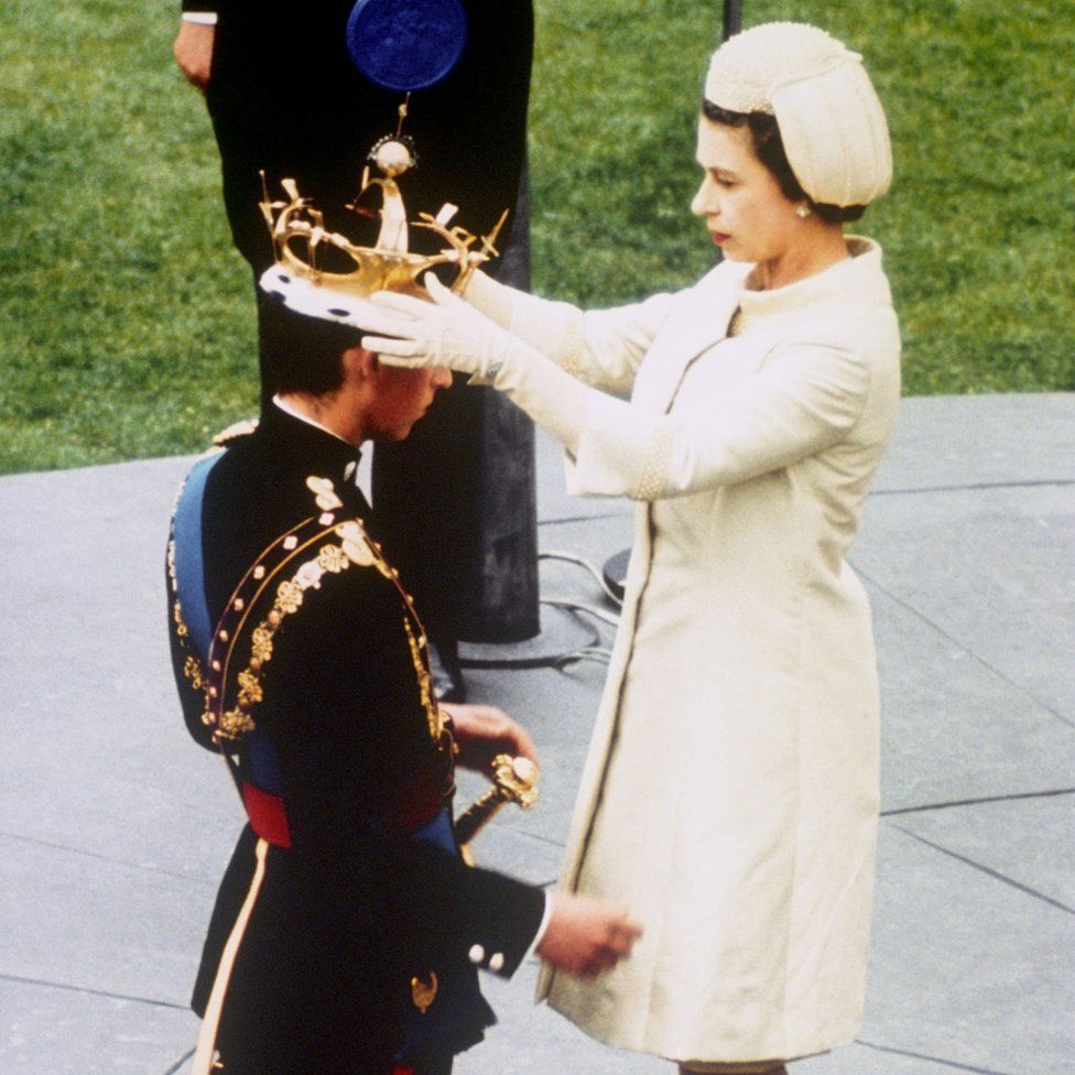 Queen Elizabeth II formally invests her son Prince Charles with the Coronet of the Prince of Wales during a ceremony at Caernarfon Castle in Cardiff
