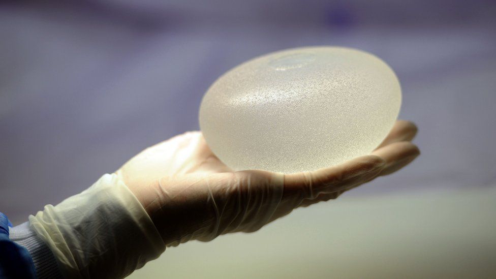 Hand holding silicone breast implant