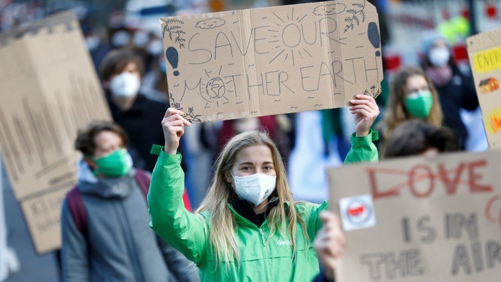 Climate change protesters wearing masks march in Bonn, Germany, March 2019
