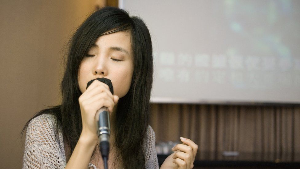 Young woman singing karaoke.