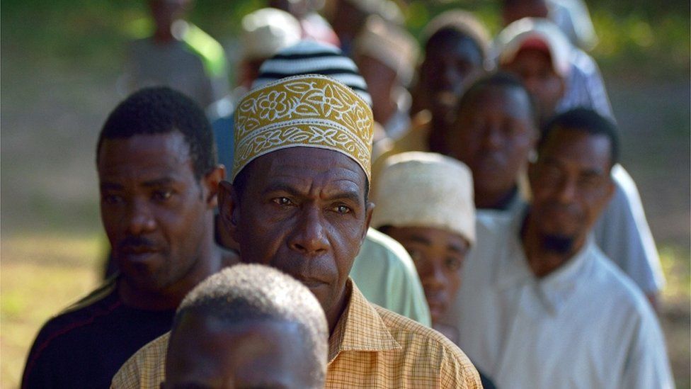 Tanzanian men queue to vote for the Tanzanian presidential election at a polling station on October 25, 2015 in Zanzibar