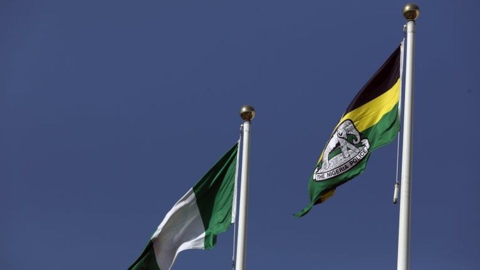 A flag of the Nigeria Police Force flies next to the Nigerian national flag at the Louis Edet House, headquarters of the police in Abuja, Nigeria.