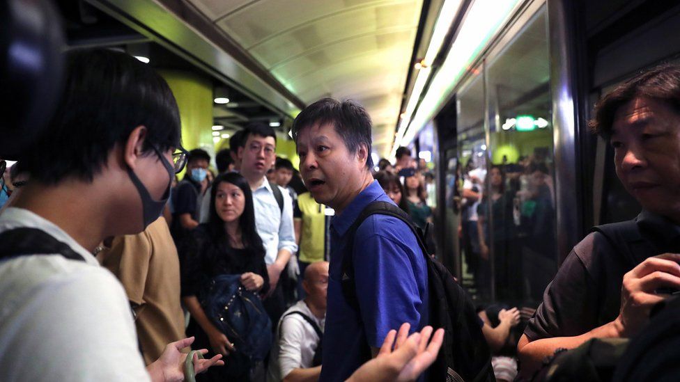 An angry stranded passenger argues with Anti-extradition bill protesters