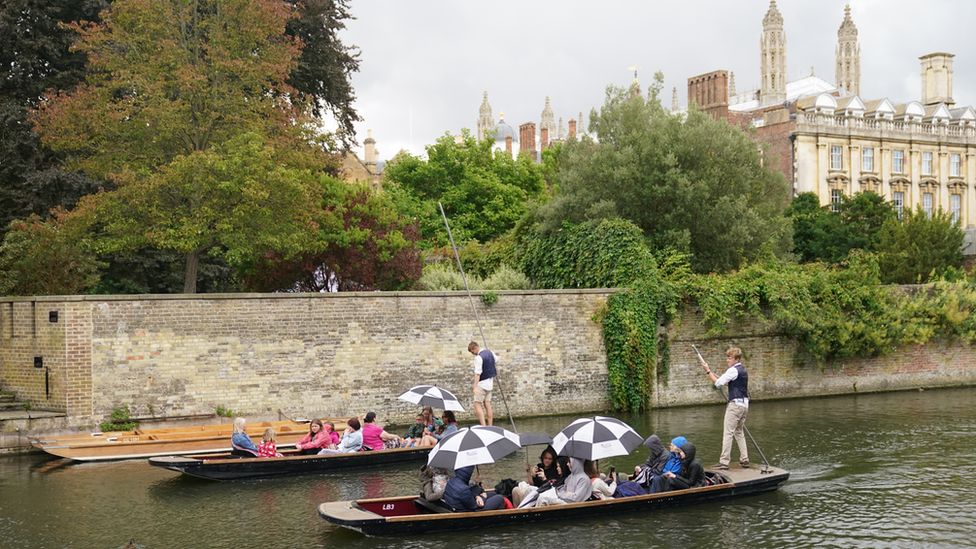 People sheltering from rain whilst punting