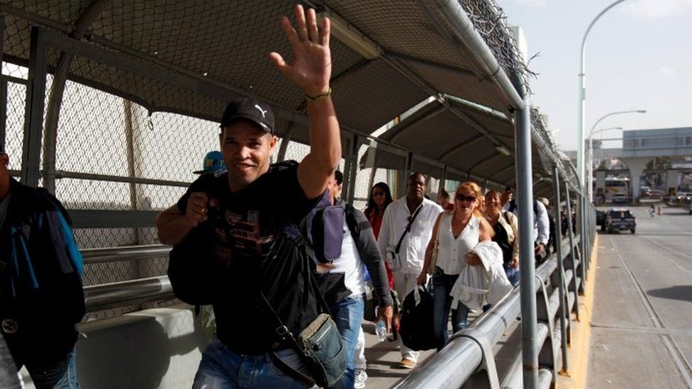 A Cuban migrant waves as he walks next to others after arriving by plane from Panama to Ciudad Juarez, at the Mexican border crossing with El Paso, Texas, February 23, 2016.