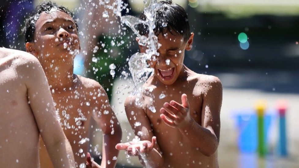 Дети играют в парке в Сиэтле во время сильной жары