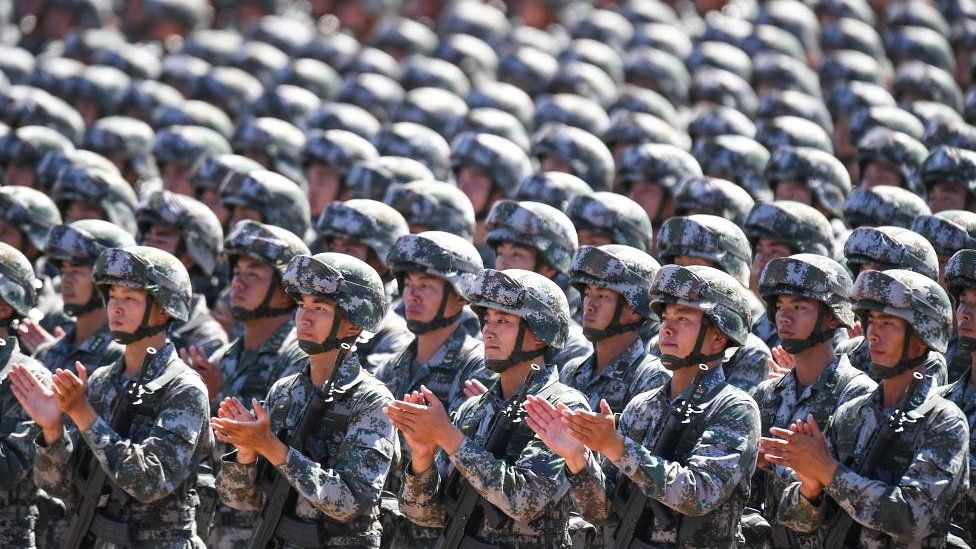 Chinese soldiers applaud during a military parade in China's northern Inner Mongolia region on July 30, 2017