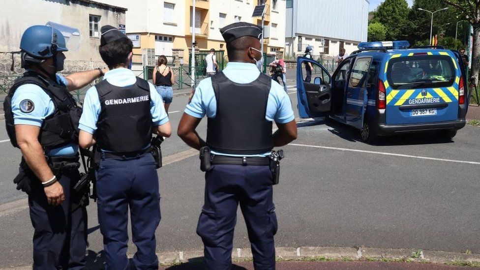 French officers stand around a vehicle as they search for a gunman on the loose in the Dordogne region