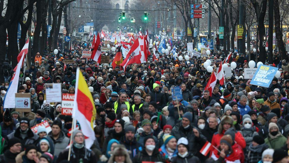 Ljudi nose austrijske zastave dok demonstriraju protiv mjera austrijske vlade Covid 8. siječnja