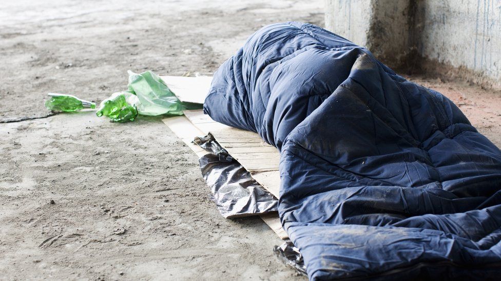 A homeless man sleeping on cardboard