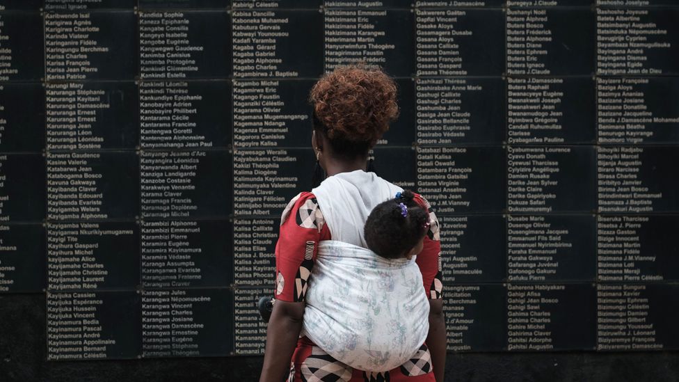 A woman carrying her child looks at the wall of victims' names as Rwanda marks the 25th anniversary of the 1994 Genocide at the Kigali Genocide Memorial in Kigali, Rwanda - 8 April 2019