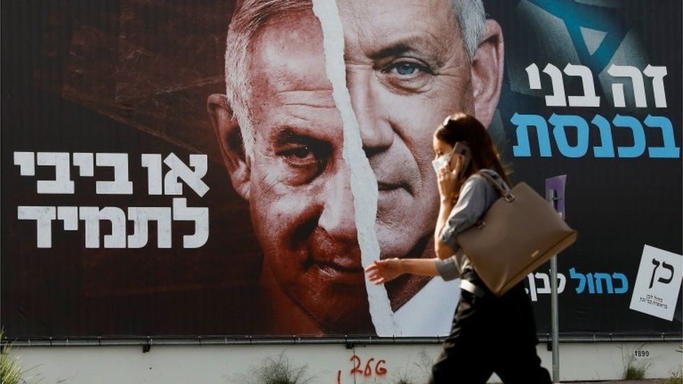 Женщина проходит мимо плаката предвыборной кампании Израиля в Тель-Авиве (14.03.21)