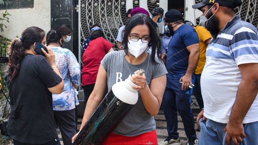 Una mujer vista con un cilindro de oxígeno, fuera de una estación de recarga en Lajpat Nagar, el 3 de mayo de 2021 en Nueva Delhi, India.