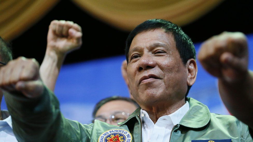 President Rodrigo Duterte raises his fist during a rally on September 13