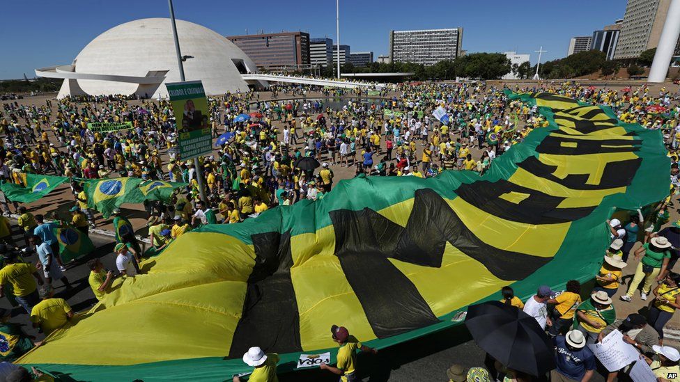 Marchers carrying banners that read in Portuguese "Dilma Out" and "Impeachment Now," in Brasilia, Brazil on 16 August 2015