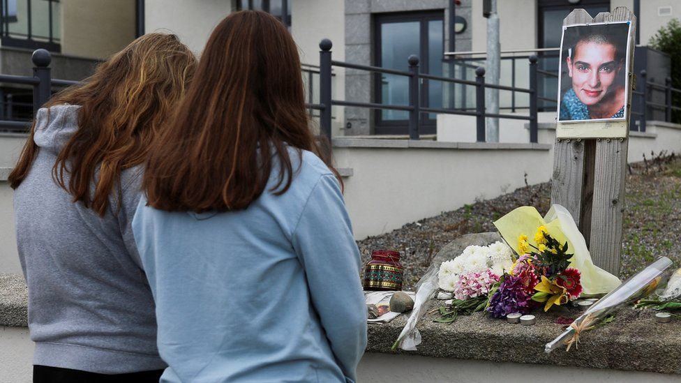 People gather outside the former home of Sinead O'Connor in the seaside town of Bray in County Wicklow, Ireland