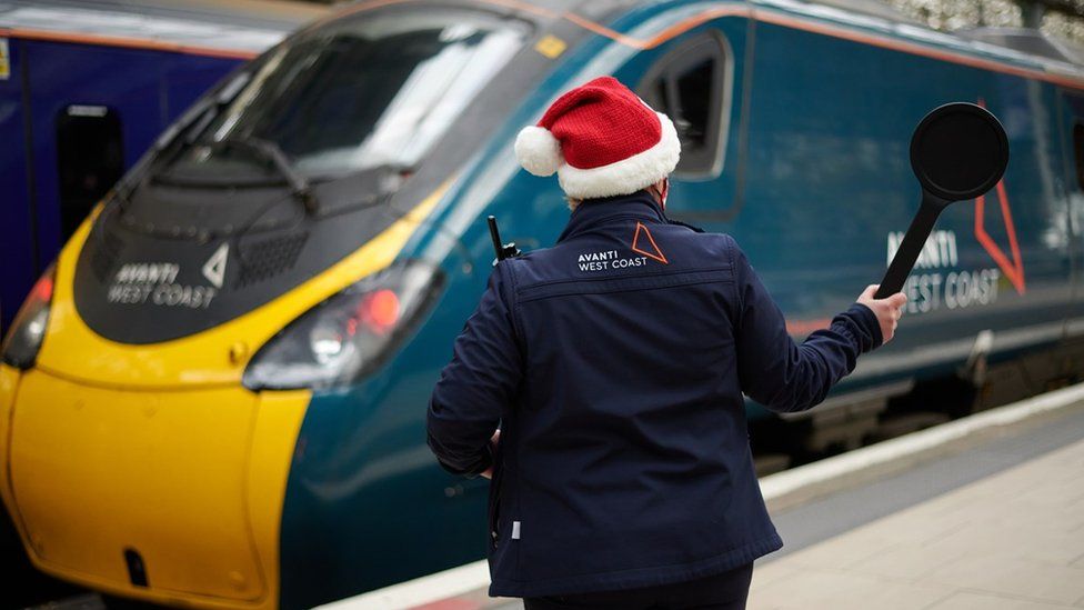 A train conductor with a Santa hat