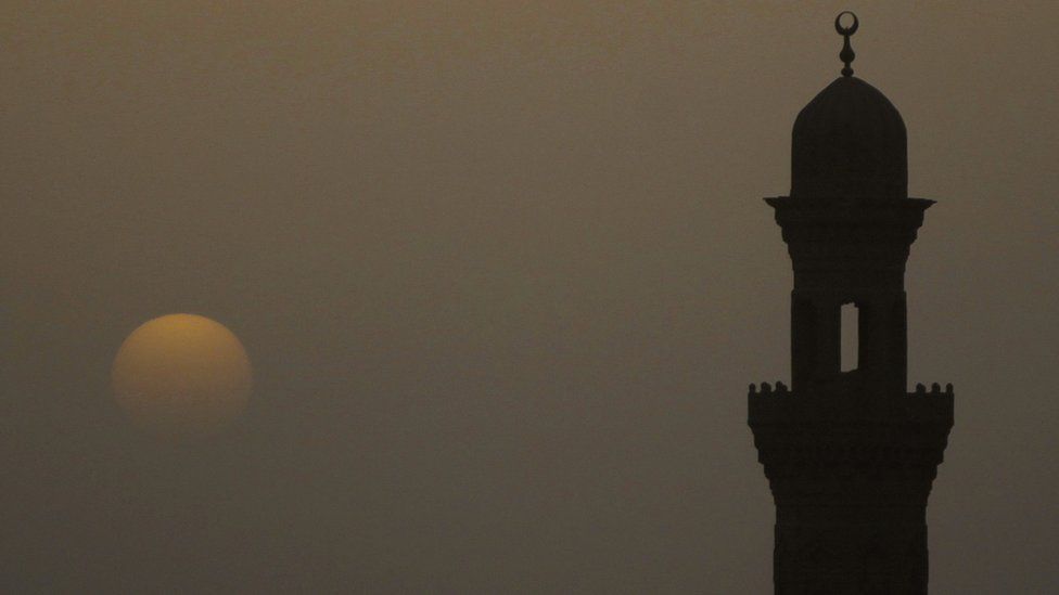 Minaret of a mosque is pictured during sunset on a hazy day in Cairo, April 8, 2013